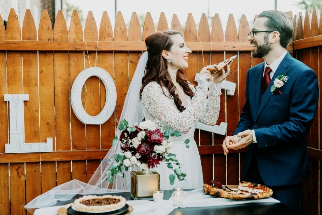 bride feeding her groom pizza