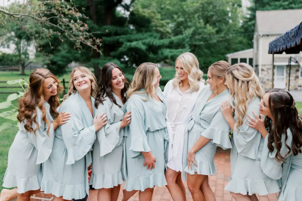 bride and bridesmaids in robes with hair and makeup