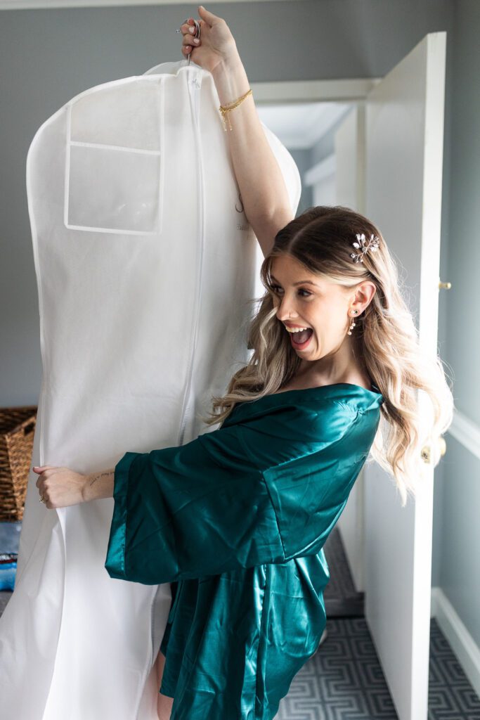 bridesmaid holding brides gown