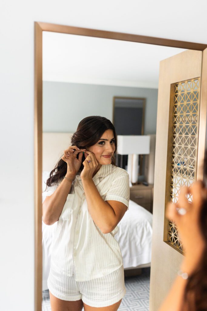 bride getting ready putting on earrings